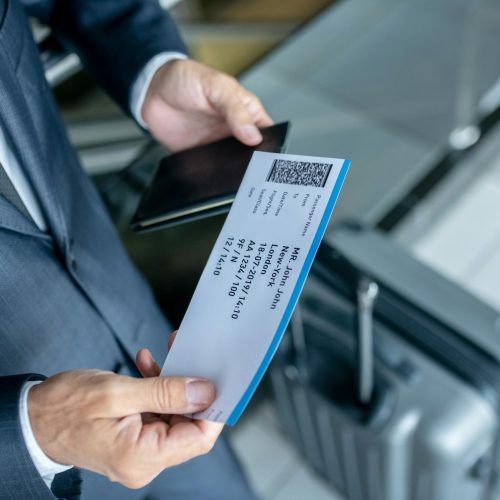 Man considering plane ticket at airport